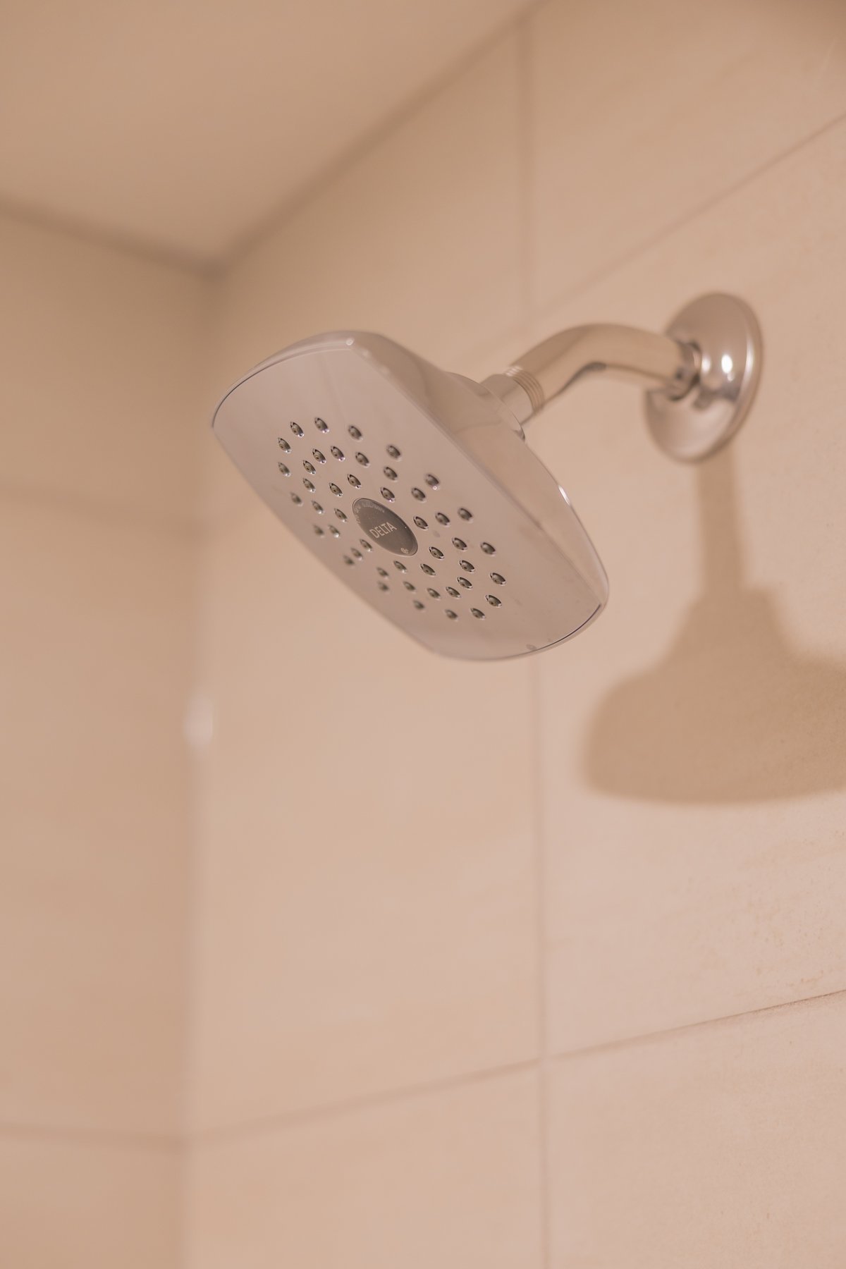 Clean black shower hardware creates contrast against the light tile surround in this finished basement bathroom.