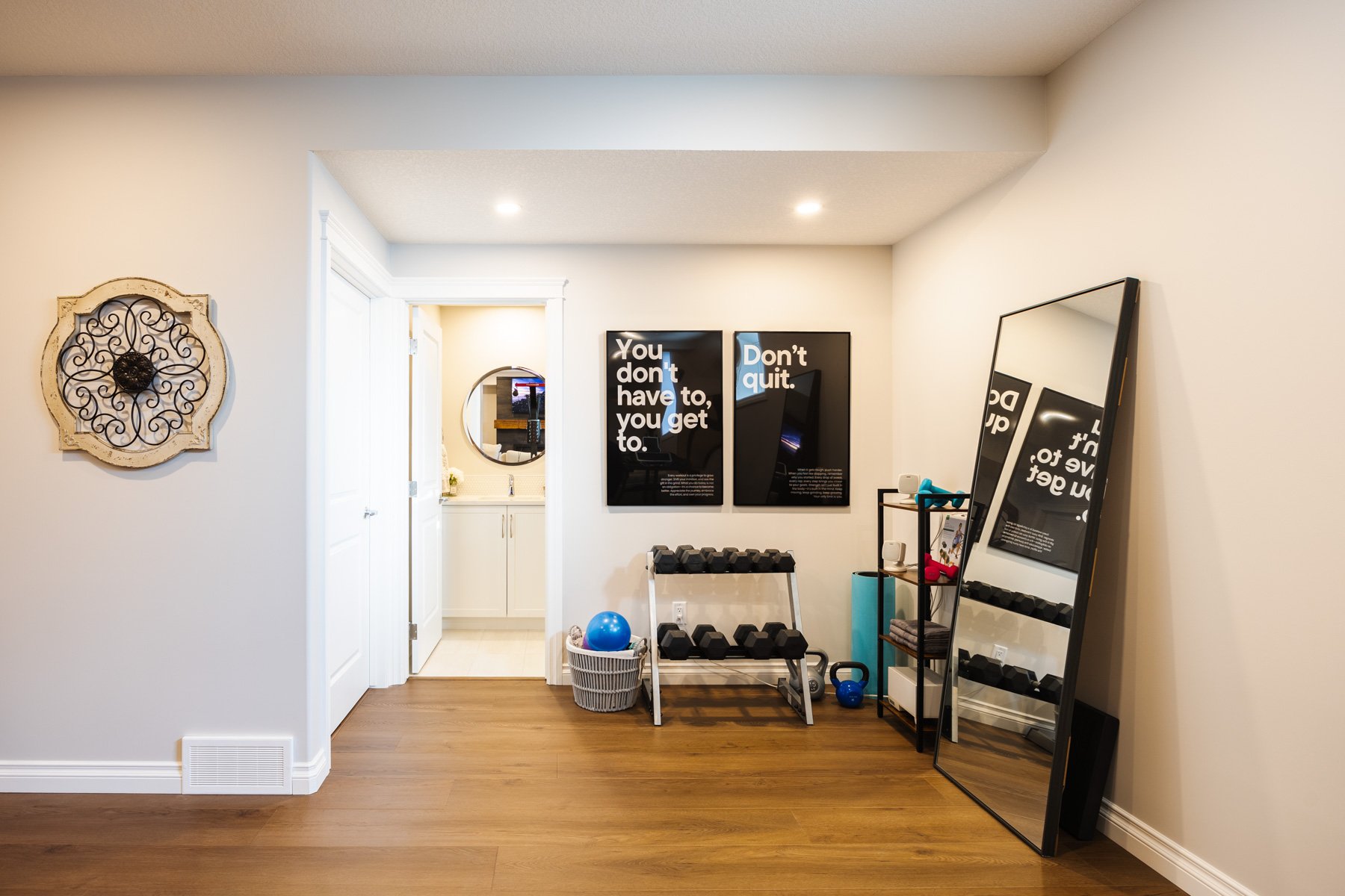 A dedicated home gym with free weights, mirrors, and fitness equipment makes this basement development work harder for the family.