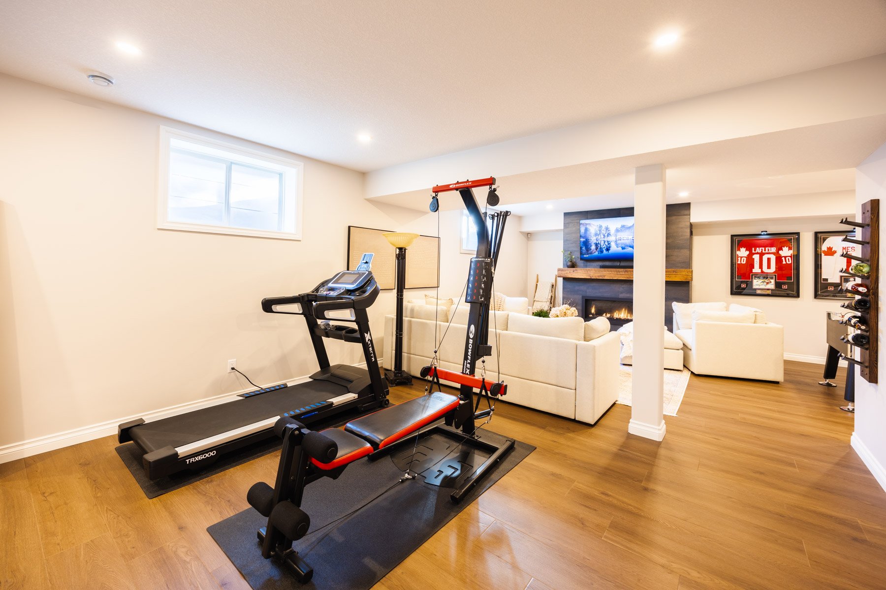 This Calgary basement renovation creates easy flow between the workout area and the relaxed living space.