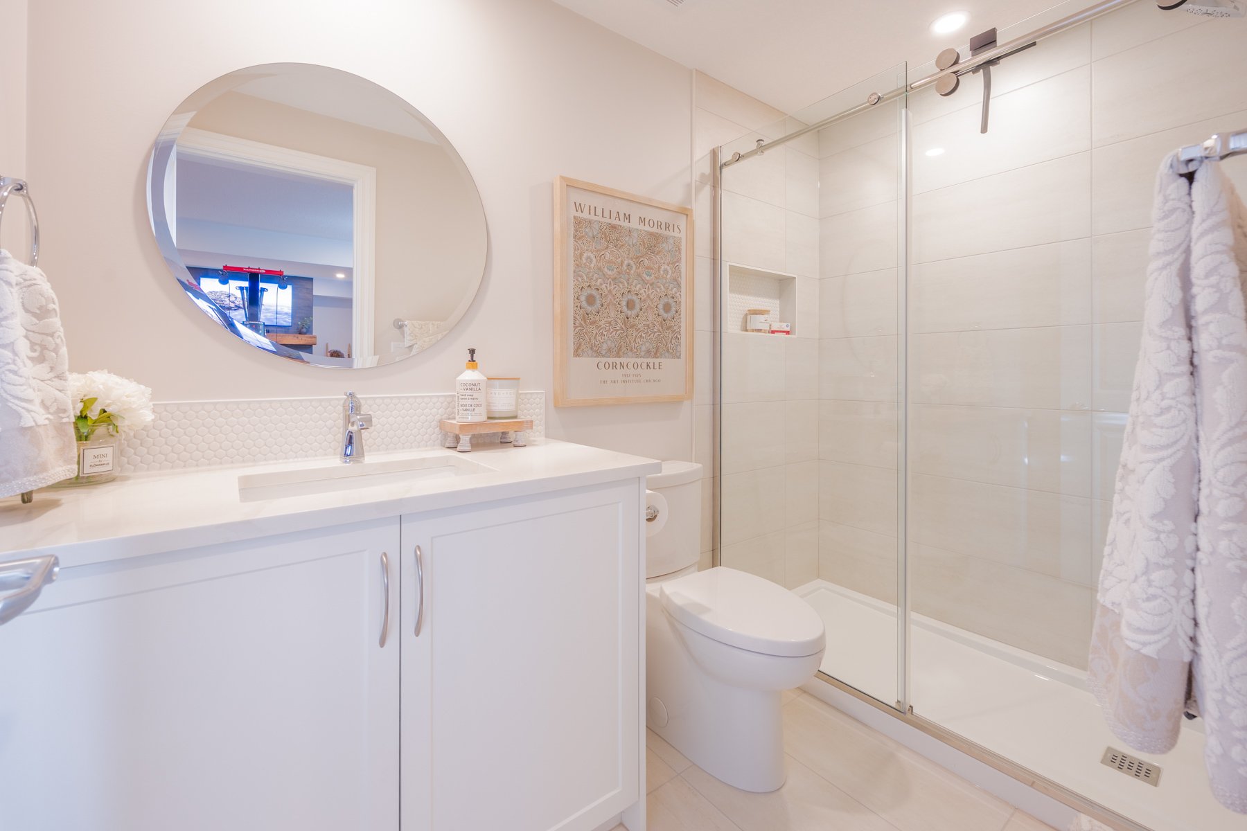 A welcoming basement bathroom finished with white cabinetry, brushed hardware, and a simple, refined palette.